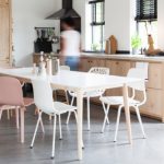 witte eettafel met witte eetkamerstoelen in houten keuken