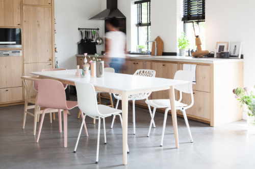 witte eettafel met witte eetkamerstoelen in houten keuken