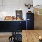 zwarte keuken met houten eettafel en zwarte composiet eetkamerstoelen