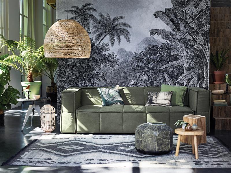 woonkamer met jungle behang groene bank en rieten hanglamp