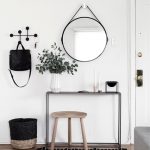 hal met zwarte sidetable en ronde spiegel