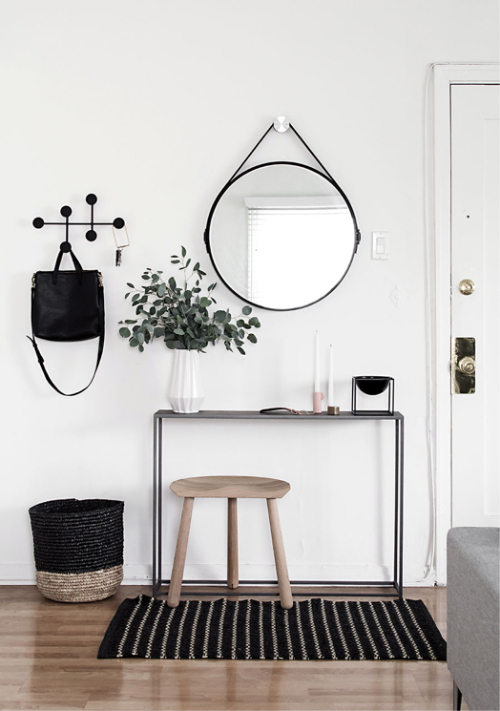 hal met zwarte sidetable en ronde spiegel