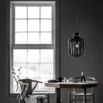 hanglamp van zwrat glas boven eettafel met wishbne chairs