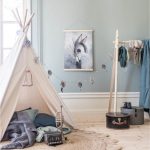 Witte tipi speeltent met rond jute vloerkleed aan de muur hangt een poster van mrs mighetto