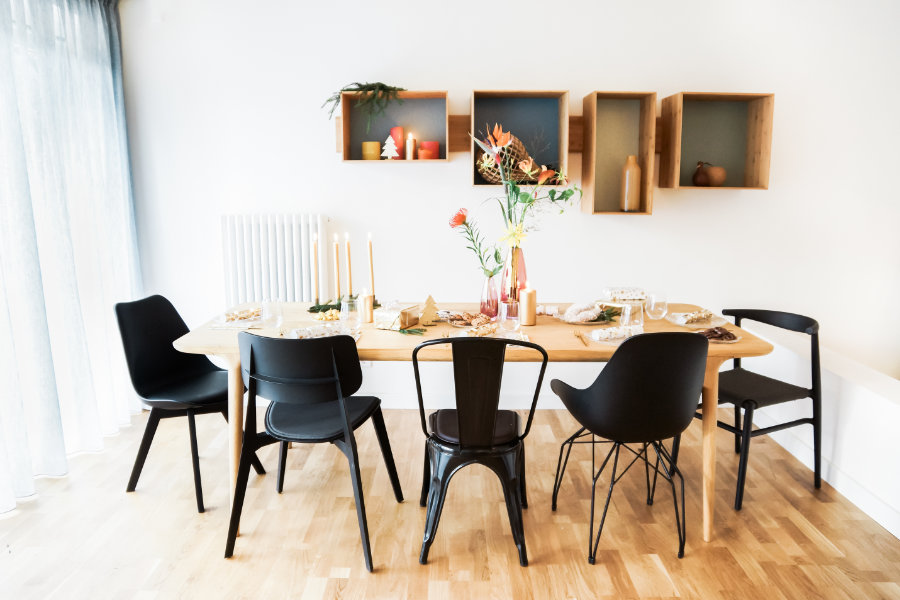 houten eettafel met zwarte eetkamerstoelen van hout, metaal en kunststof