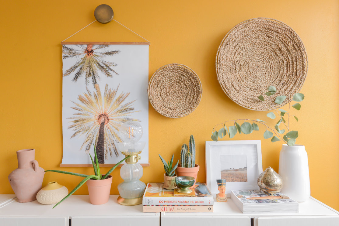 vazen en boeken op witte kast voor gele muur binti home wown