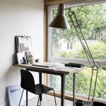 werkplek met grote vloerlamp en houten bureau voor made