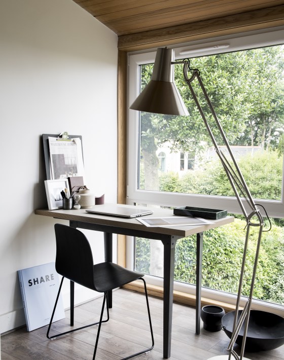 werkplek met grote vloerlamp en houten bureau voor made