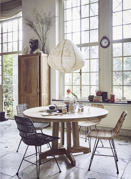 grote teakhouten ronde tafel met rotan eetkamerstoelen