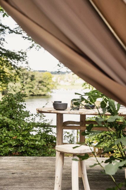 Terras met tarp schaduwdoek en houten krukje