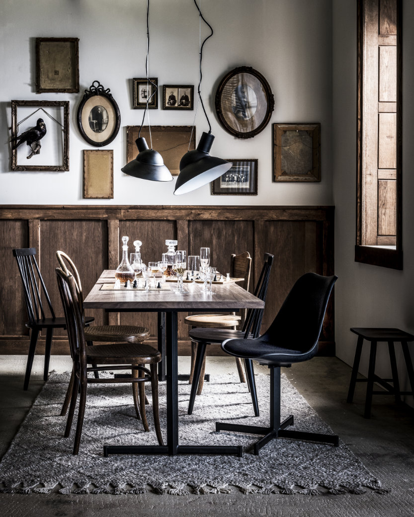 stoere eettafel met zwarte eettafelstoelen en industriele lampen