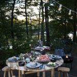 buiten eten aan een ronde houten tafel met houten krukjes