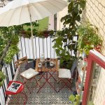 balkon met tegelvloer en rood bistro tuinset en kruiden en planten