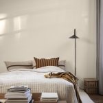 slaapkamer ferm living met zwarte wandlamp en beige bedsprei