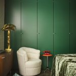 slaapkamer met groene kastenwand en fauteuil met teddy bekleding