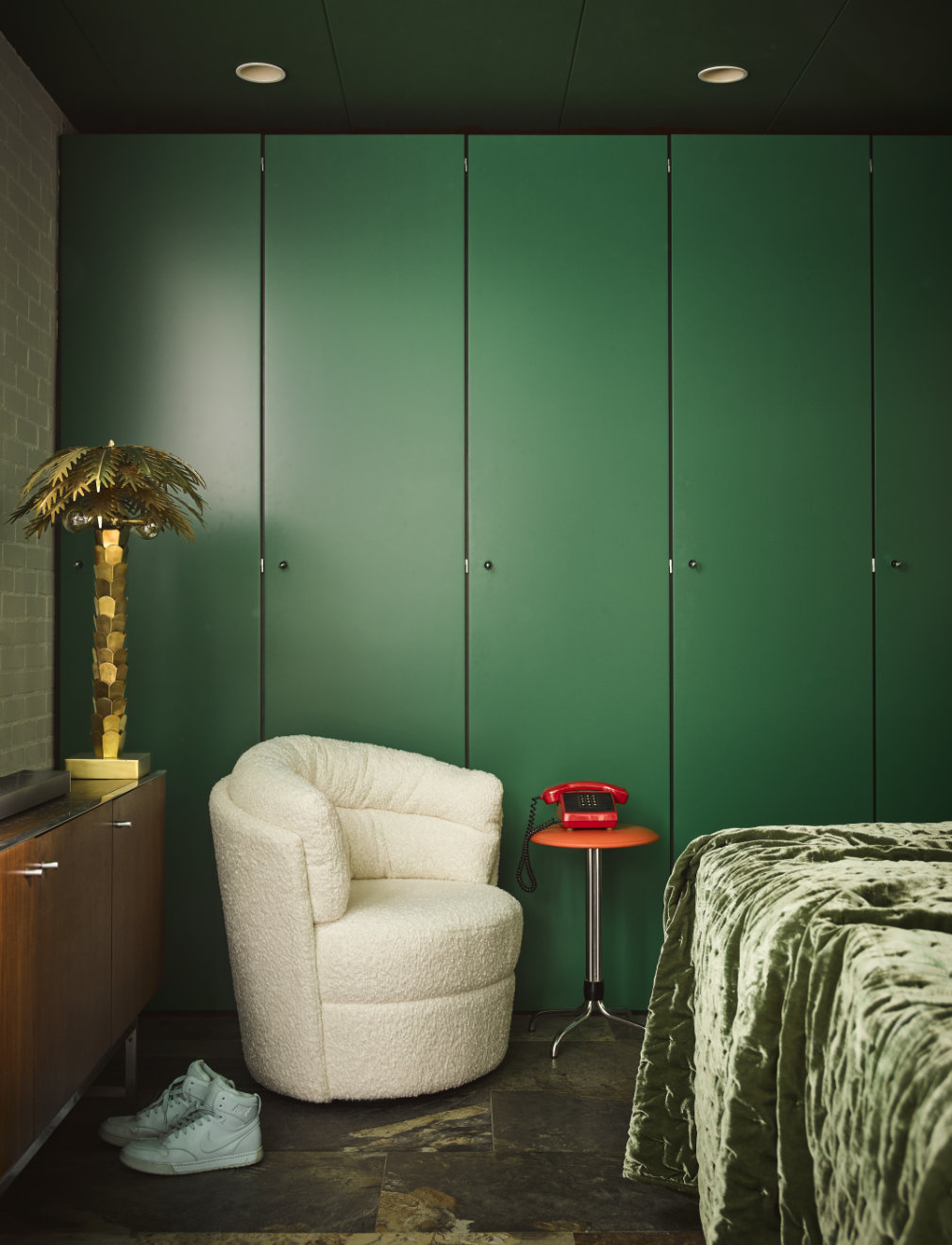 slaapkamer met groene kastenwand en fauteuil met teddy bekleding