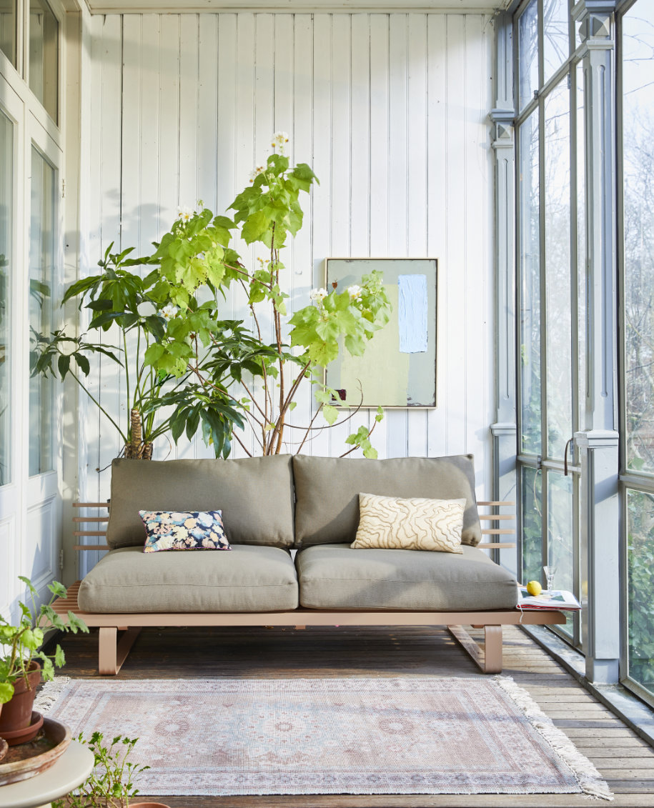 lichte serre met tuinbank en vloerkleed