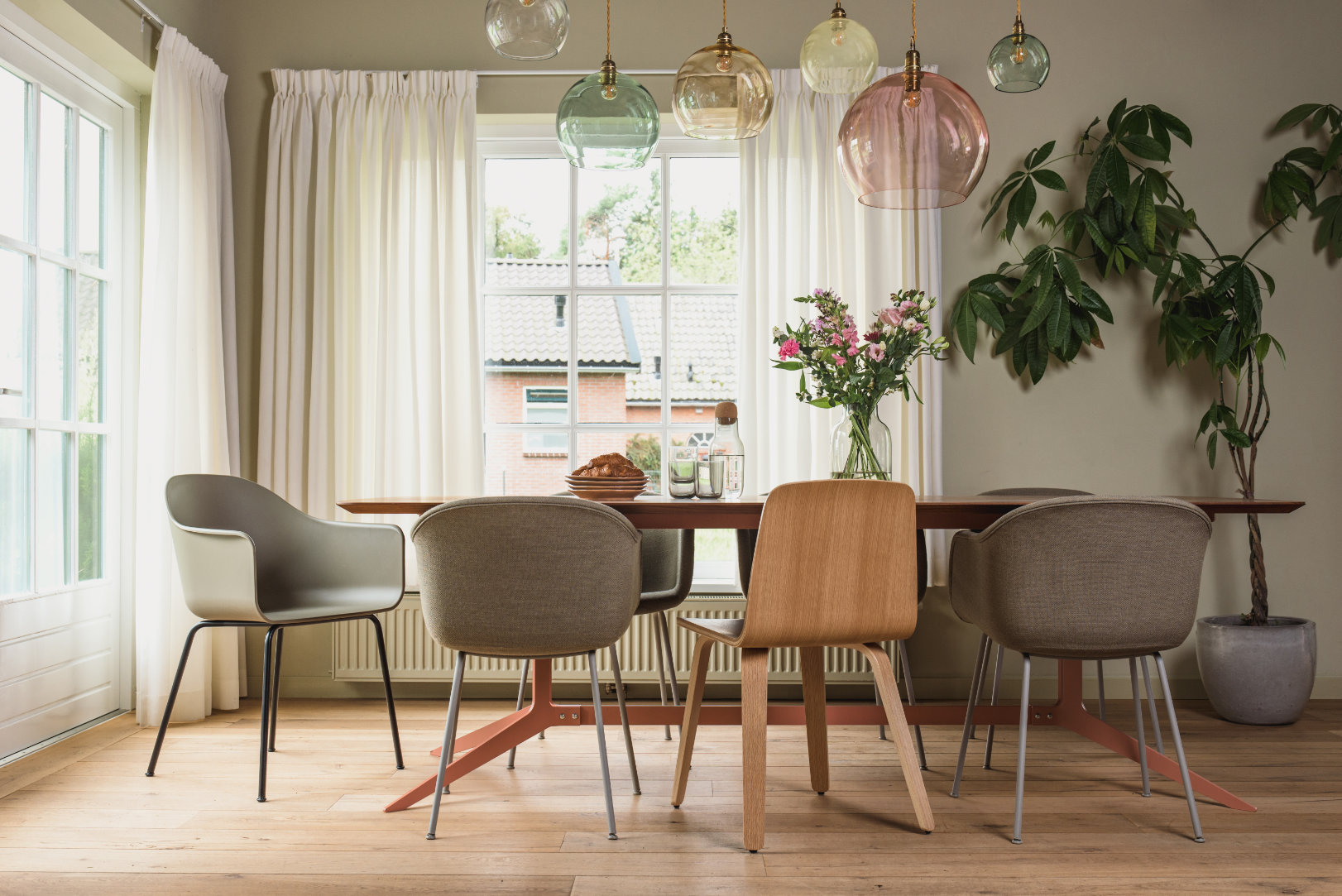 eetkamer met verschillende eetkamerstoelen en glazen bollen hanglamp van hellochair